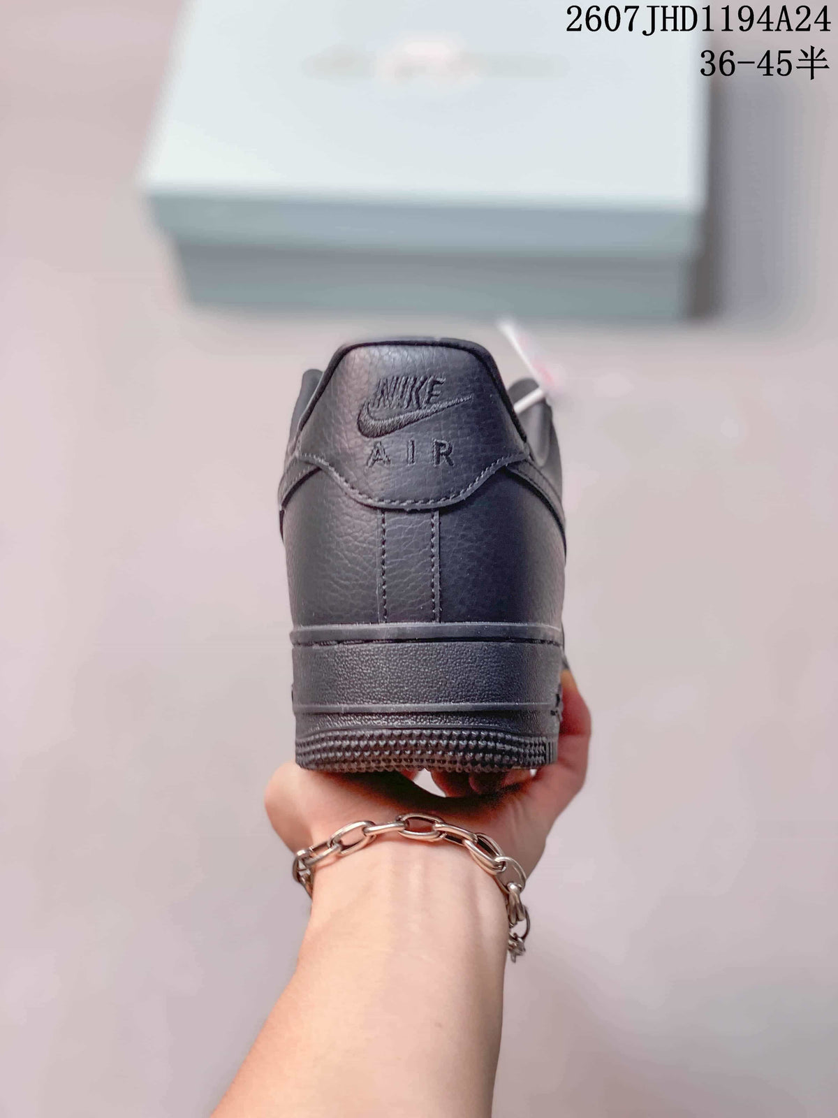 Rear view of a black low-top sneaker showing the padded heel, tonal Air branding and textured outsole.