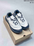 Pair of white and black DESCENTE low-top hiking sneakers displayed on a shoebox.