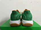 Rear view of green Nike basketball shoes with white midsoles and gum-colored outsoles.