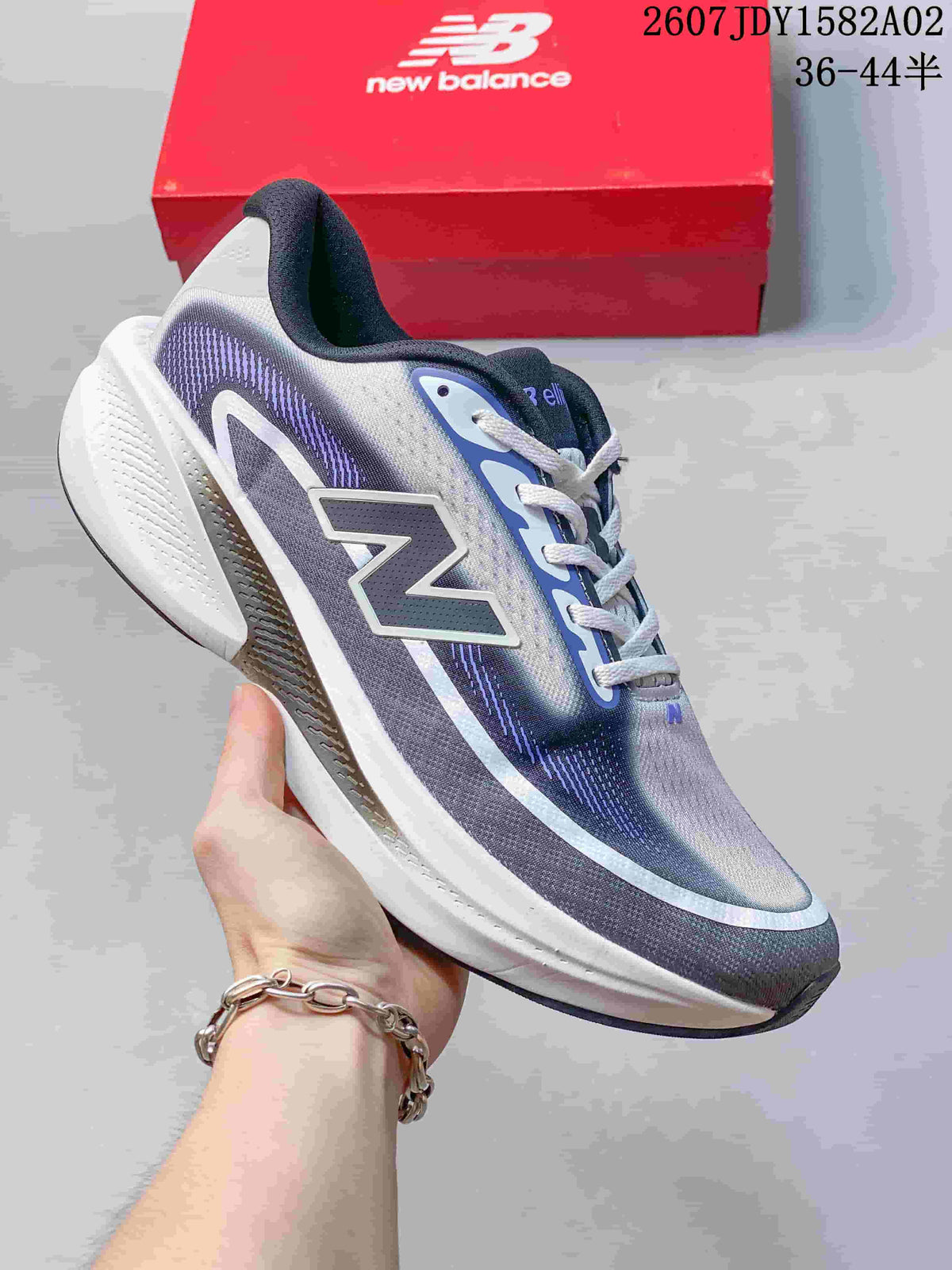 New Balance running shoe in a gray and purple gradient colorway with a thick white sole.