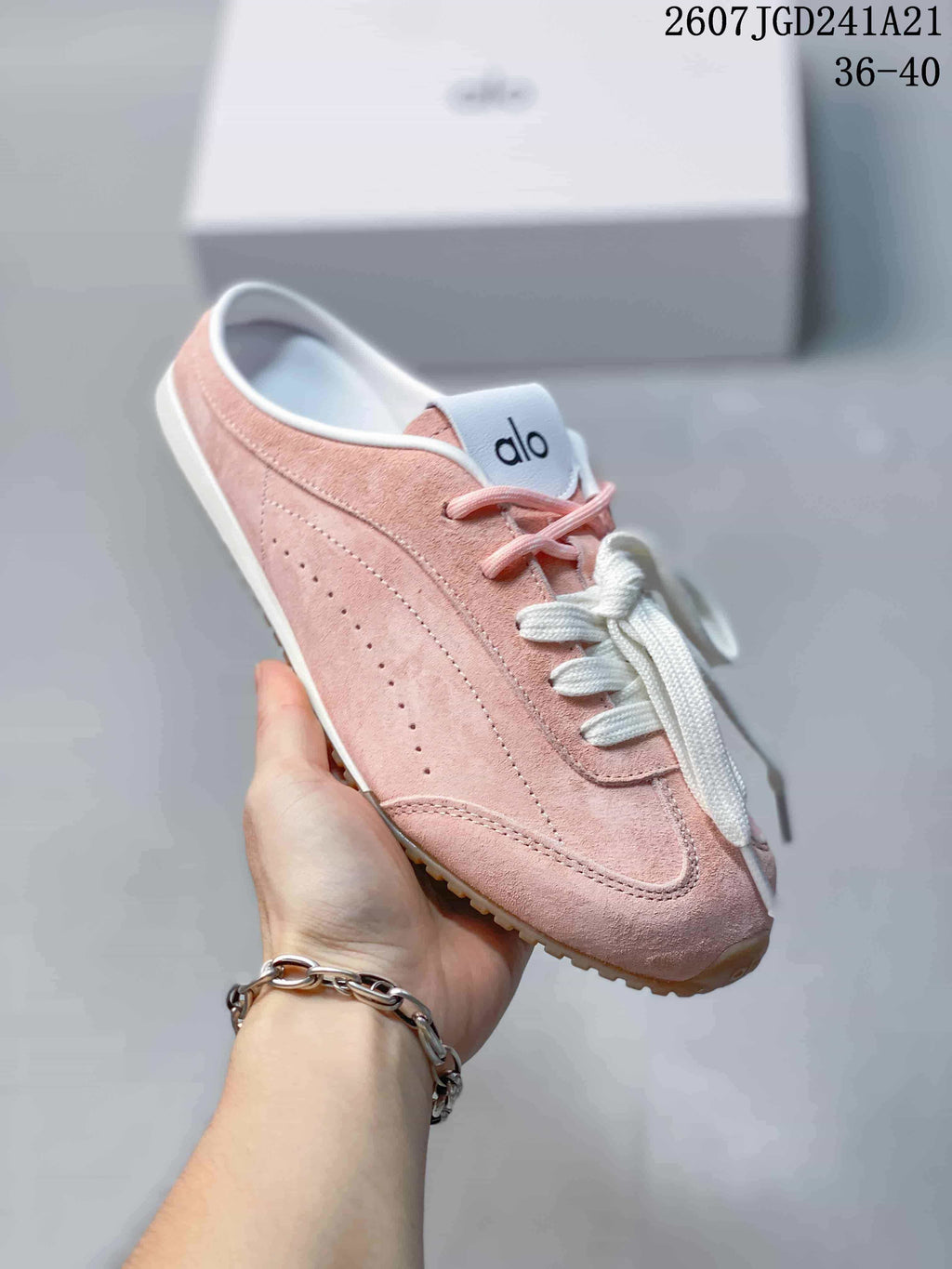 Angled view of the pink sneaker showing the lace-up front, white trim, and low sole.