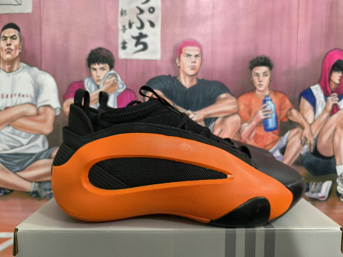 Side profile highlighting the orange frame, black mesh panel, and sculpted sole