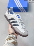 Angled side view showing Samba branding, black side stripes, white upper and grey toe panel.