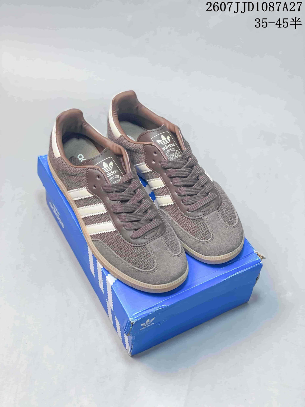 Pair of brown and white adidas Samba ADV sneakers displayed on a blue adidas shoe box.