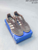 Pair of brown and white adidas Samba ADV sneakers displayed on a blue adidas shoe box.