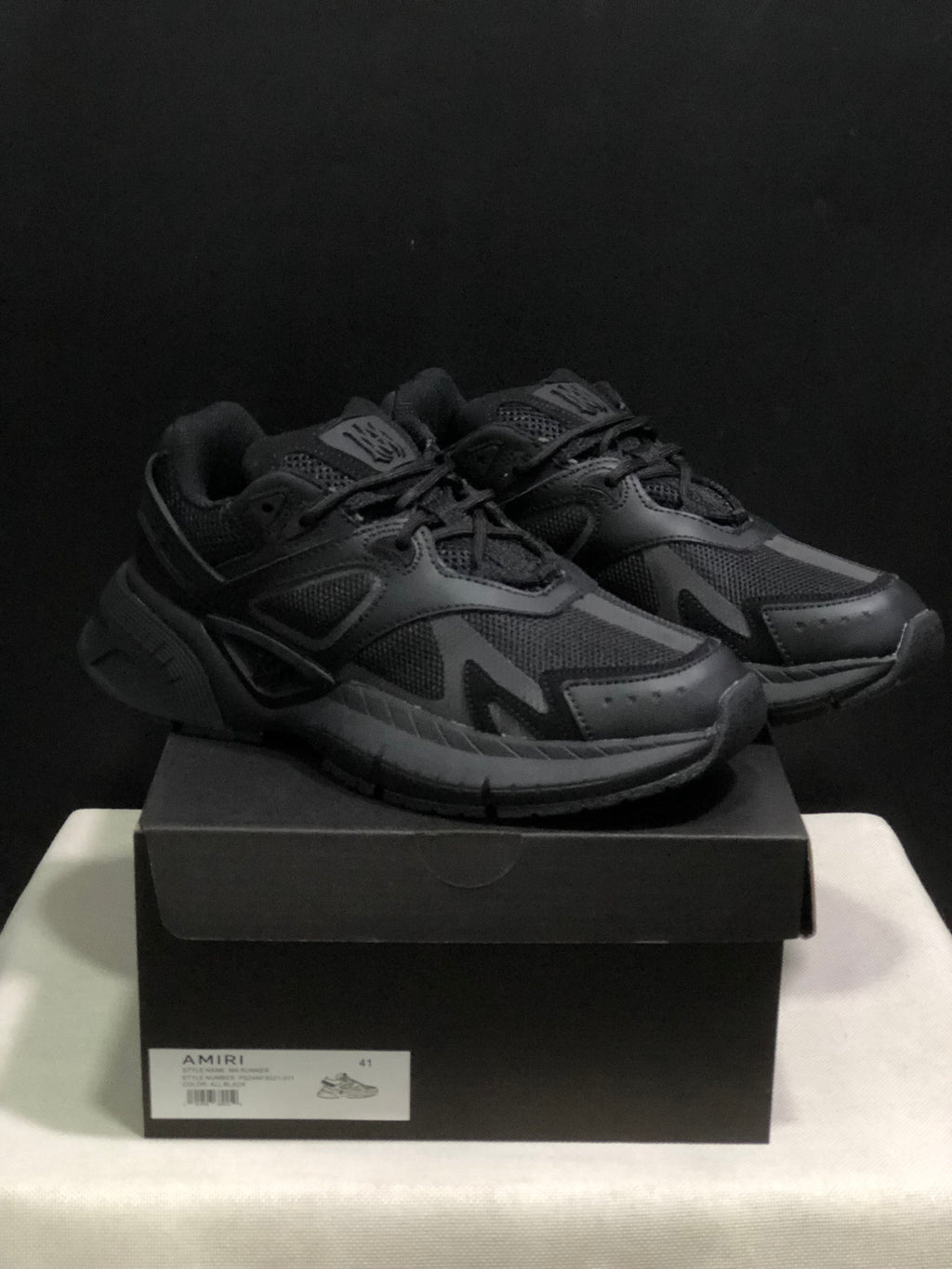 Pair of black AMIRI MA Runner sneakers displayed on a branded shoe box; the box label shows size 41.