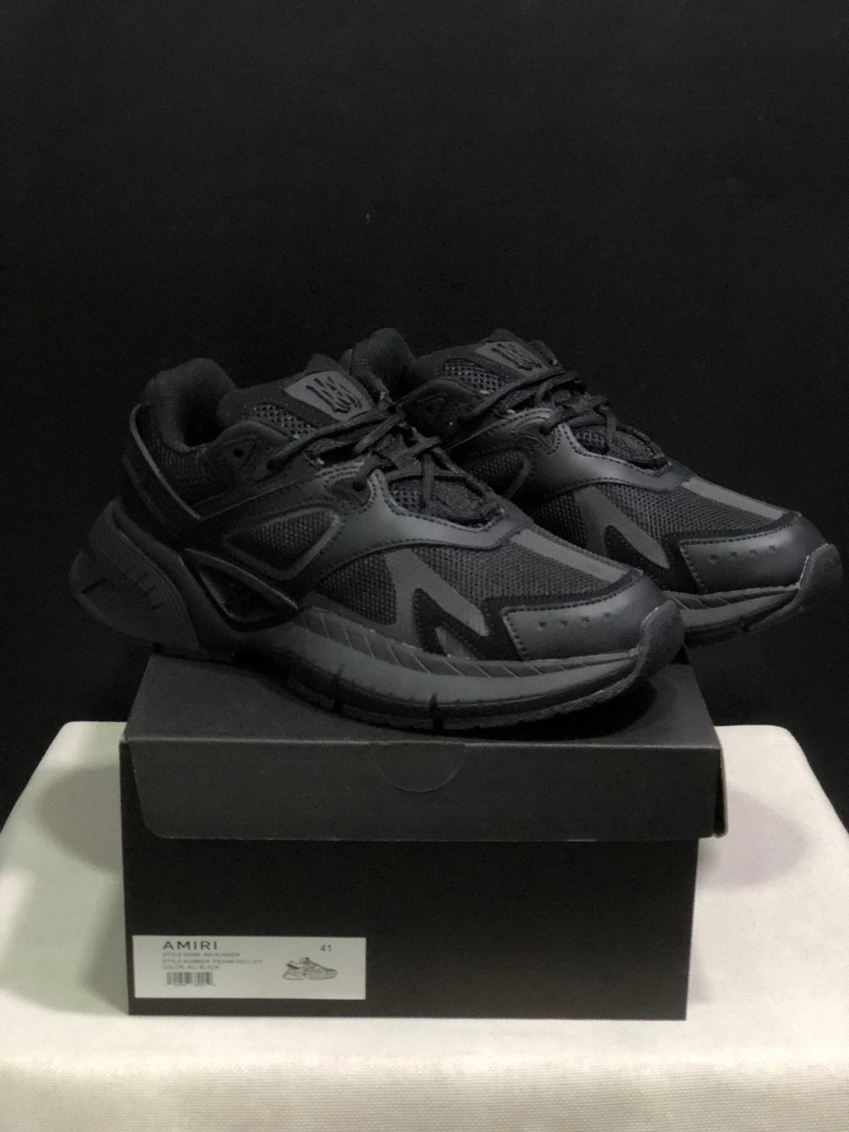 Pair of black AMIRI MA Runner sneakers displayed on a branded shoe box; the box label shows size 41.
