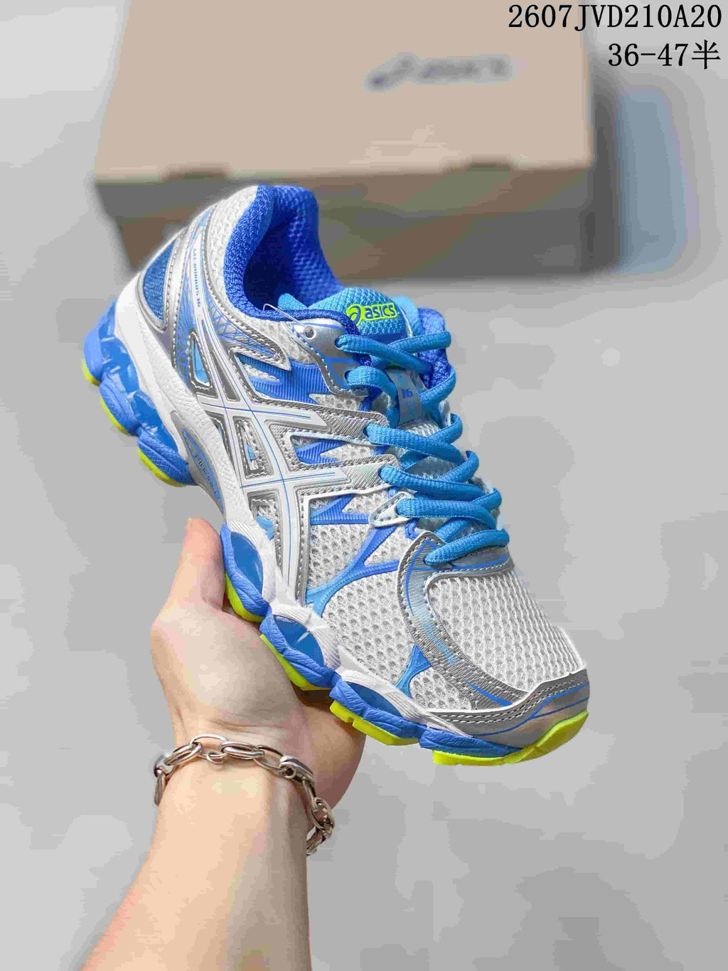 Angled front-side view of the ASICS sneaker with white mesh panels, blue overlays and lime outsole accents.