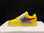 Side profile of one yellow sneaker showing the large red star graphic over a blue panel and BAPE lettering on the midsole.
