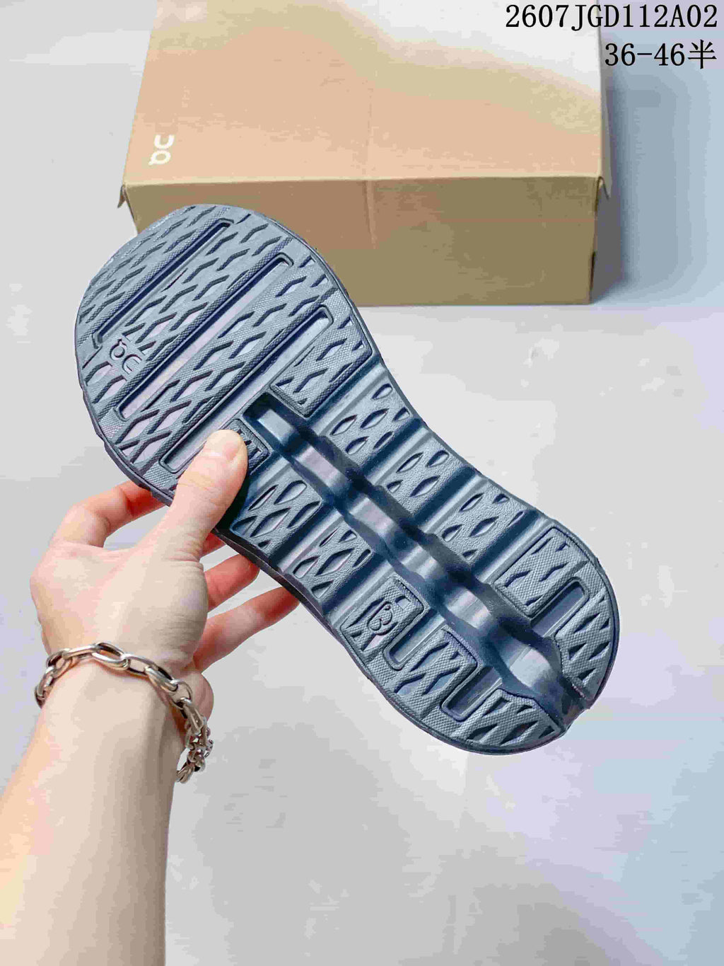 Close-up of the gray sneaker outsole showing its patterned tread and sculpted cutout details.