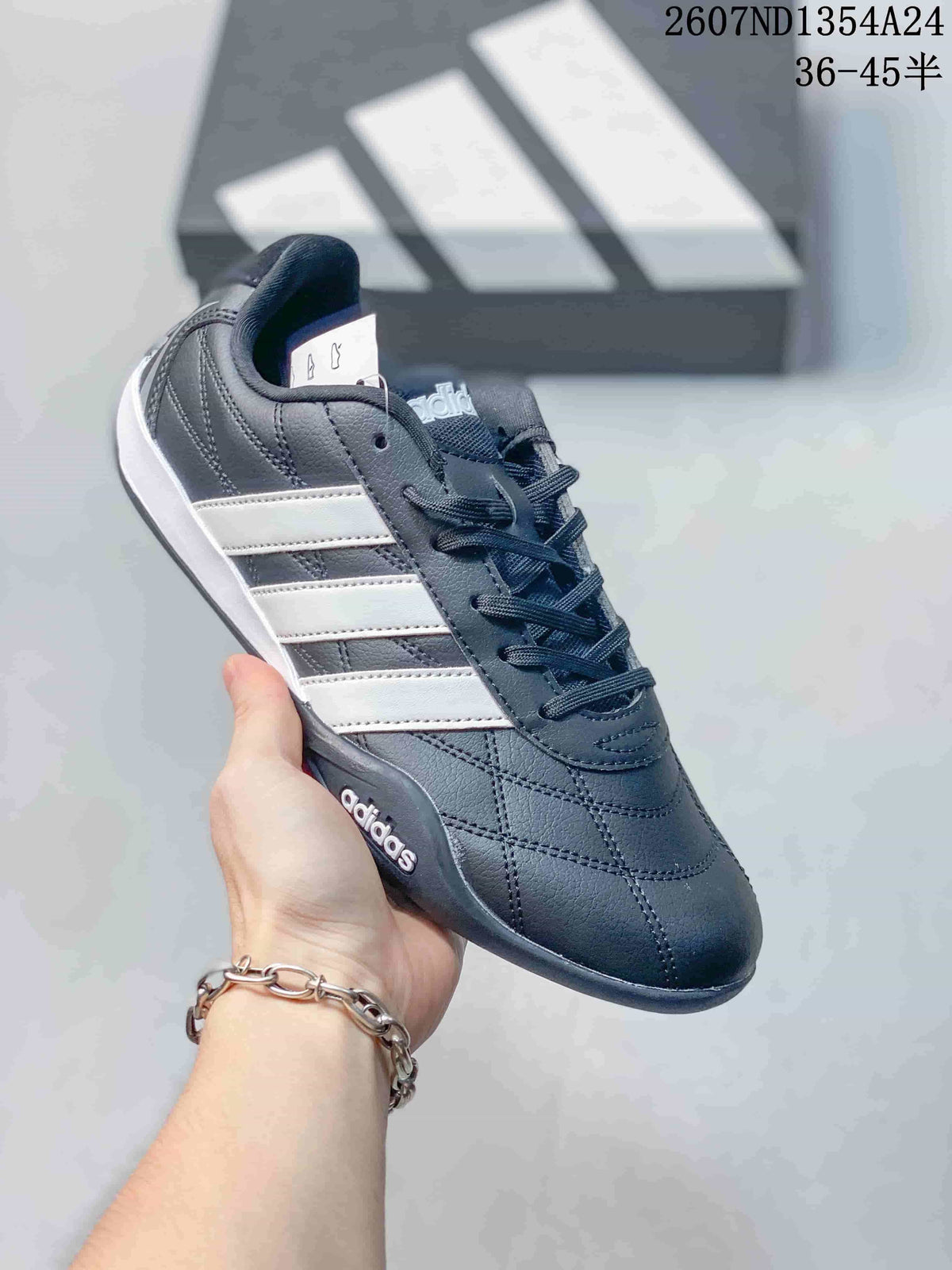 Angled side view of the adidas trainer showing the dark upper, white stripes and low-profile sole.