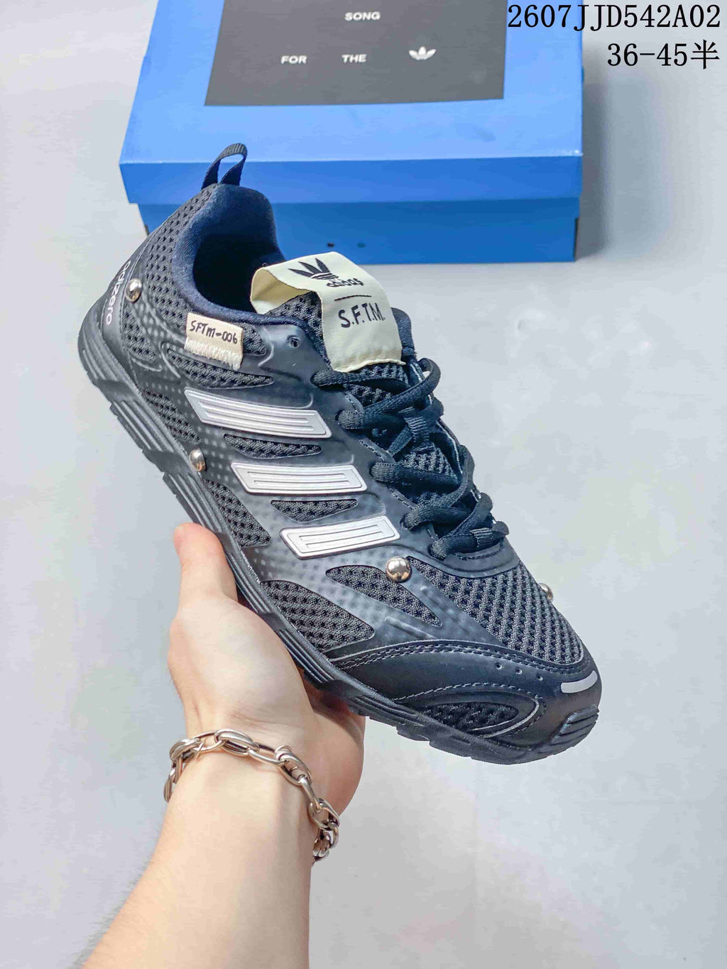 Angled side view of a charcoal sneaker with S.F.T.M. tongue branding