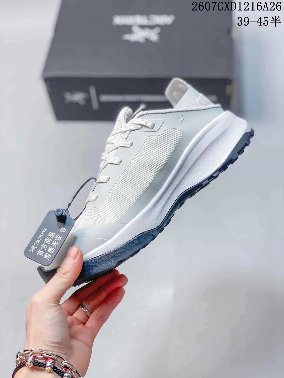 Side view of a white low-top sneaker showing layered panels, lace eyelets, raised heel and dark outsole.
