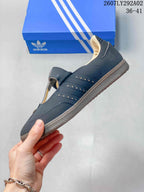 Side profile of a dark navy Adidas Samba Jane shoe with perforated side panels, cream lining, and a gum-colored outsole.
