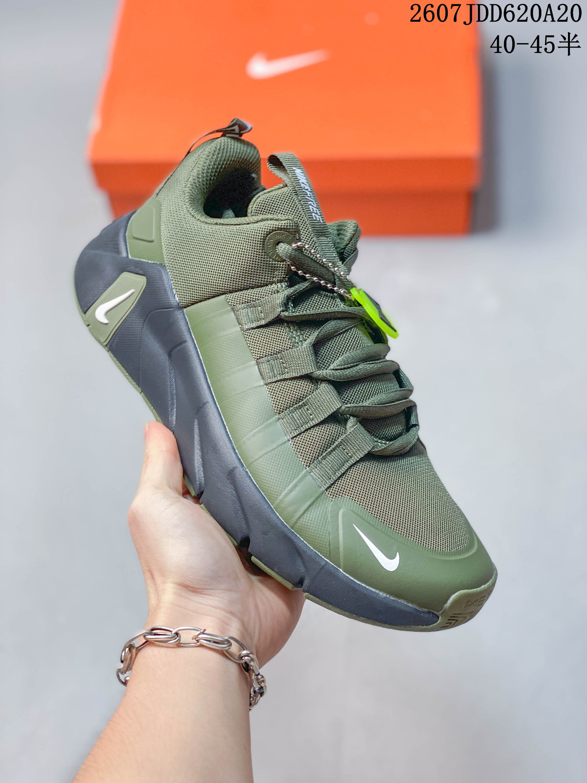 Three-quarter view of the olive green and navy Nike Free Metcon 7 training shoe showing the mesh upper, lace supports, Swoosh and segmented outsole.