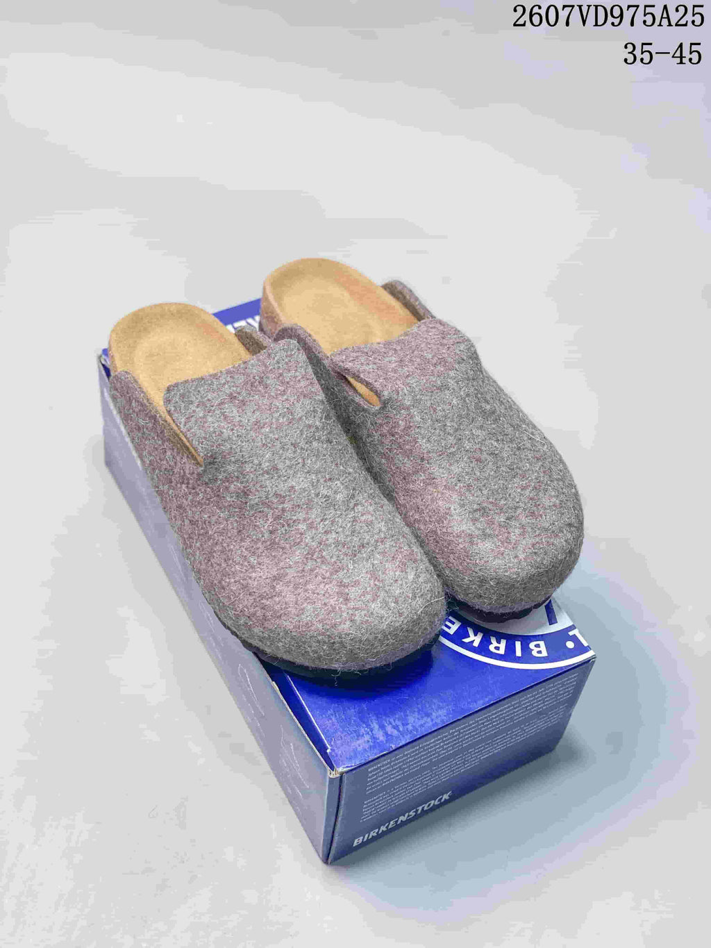 Gray and gray-pink mélange Amsterdam clogs displayed on a blue Birkenstock box.