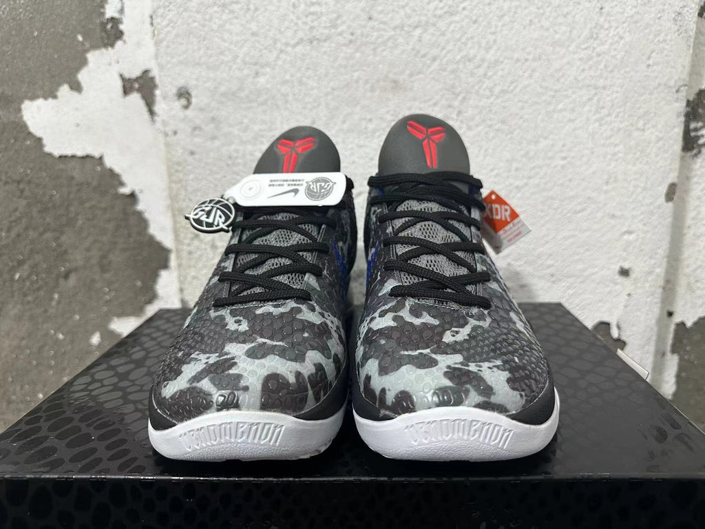 Front view of gray camouflage basketball shoes with black laces and red tongue logos