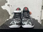 Front view of gray camouflage basketball shoes with black laces and red tongue logos