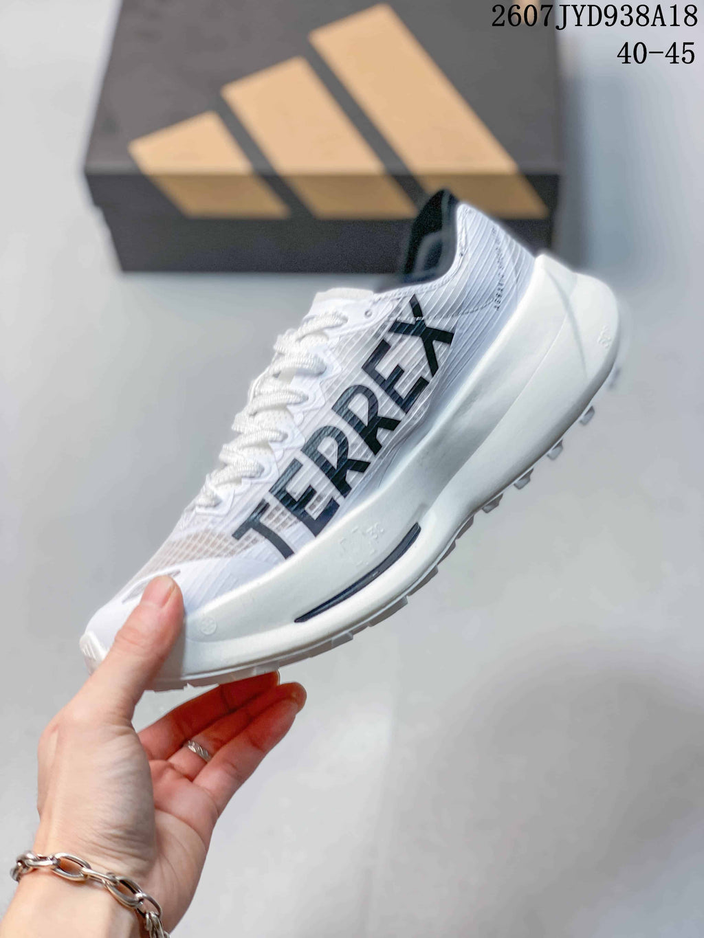 Side view showing the white upper, black Adidas stripes, lace-up construction and thick white midsole.