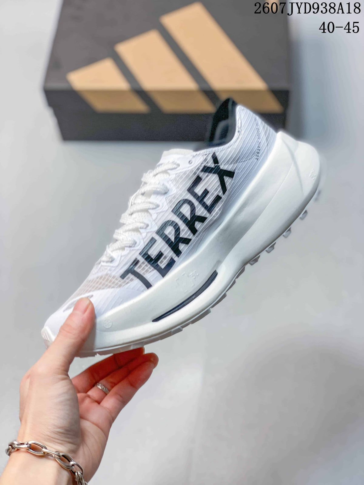 Side view showing the white upper, black Adidas stripes, lace-up construction and thick white midsole.