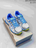 Pair of ASICS Gel-Nimbus 16 sneakers in white, blue and lime displayed on a shoebox.