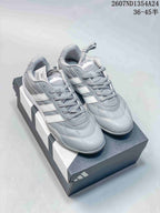 Pair of gray and white adidas Adipista sneakers displayed on a shoebox.