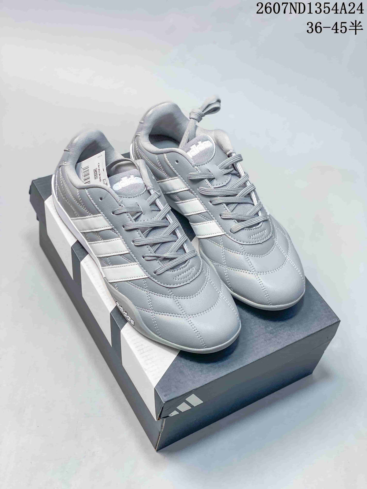 Pair of gray and white adidas Adipista sneakers displayed on a shoebox.