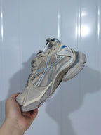 Side and outsole view of the taupe and blue Puma 2240 Runner sneaker showing the layered upper, heel structure, and textured sole.