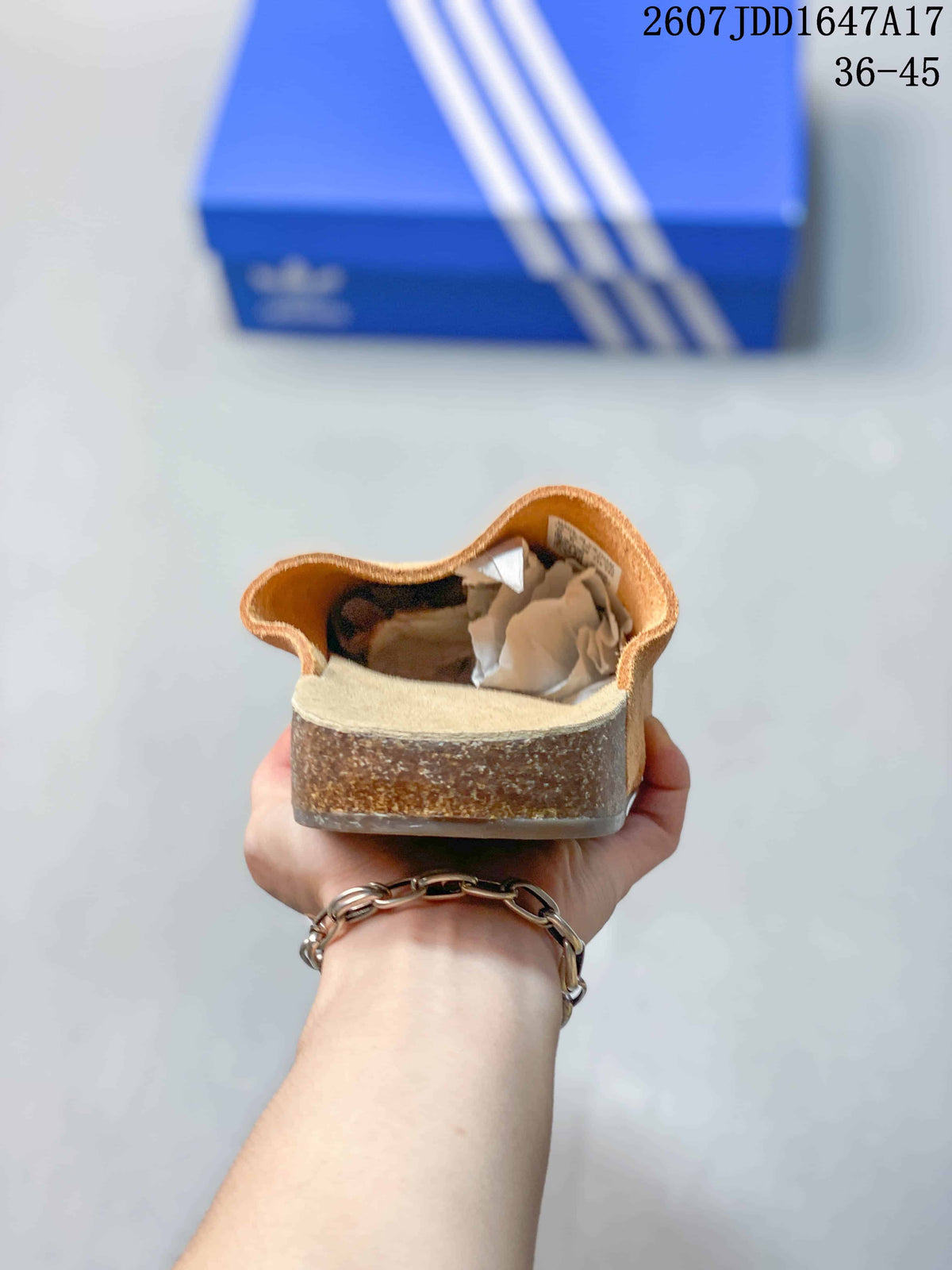 Rear view of a tan closed-toe mule showing the raised heel area, footbed, and textured outsole edge.