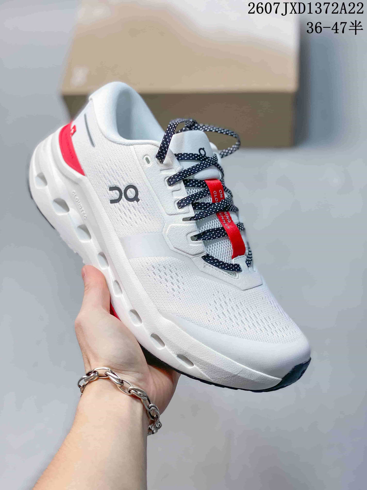 Angled side view of the white sneaker showing the On logo, red accents, lace-up design, and segmented sole.