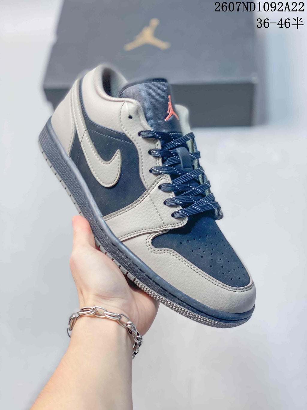 Angled side view of a gray and navy low-top sneaker showing the color-blocked upper, Swoosh, laces, and rubber outsole.