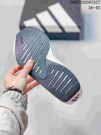 Close view of the black and gray outsole with longitudinal grooves and white accent openings.