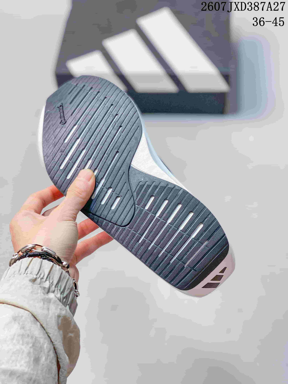 Close view of the black and gray outsole with longitudinal grooves and white accent openings.