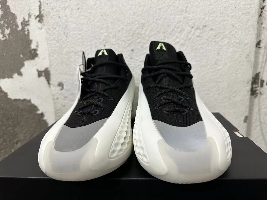 Front view of black lace-up sneakers with gray toe panels and white sculpted soles