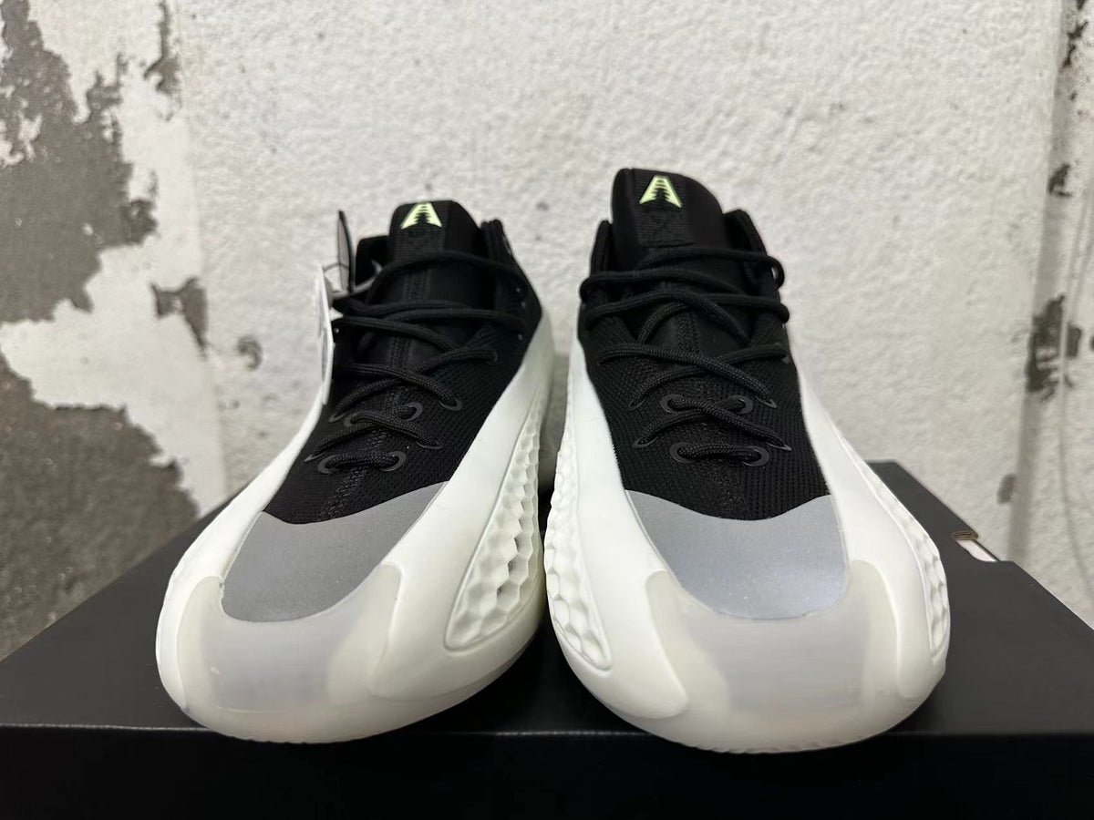 Front view of black lace-up sneakers with gray toe panels and white sculpted soles