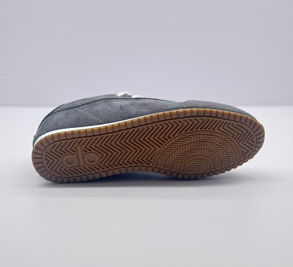 Bottom view showing the brown rubber outsole with a geometric traction pattern and Alo mark.