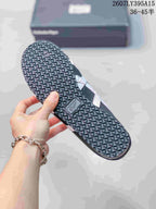 View of the black sneaker outsole showing a repeating geometric tread pattern and an Onitsuka Tiger outsole badge.