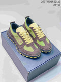 Pair of green and brown Dior Squash sneakers displayed on a shoebox, showing the contrast upper, laces, speckled sole, and yellow outsole.