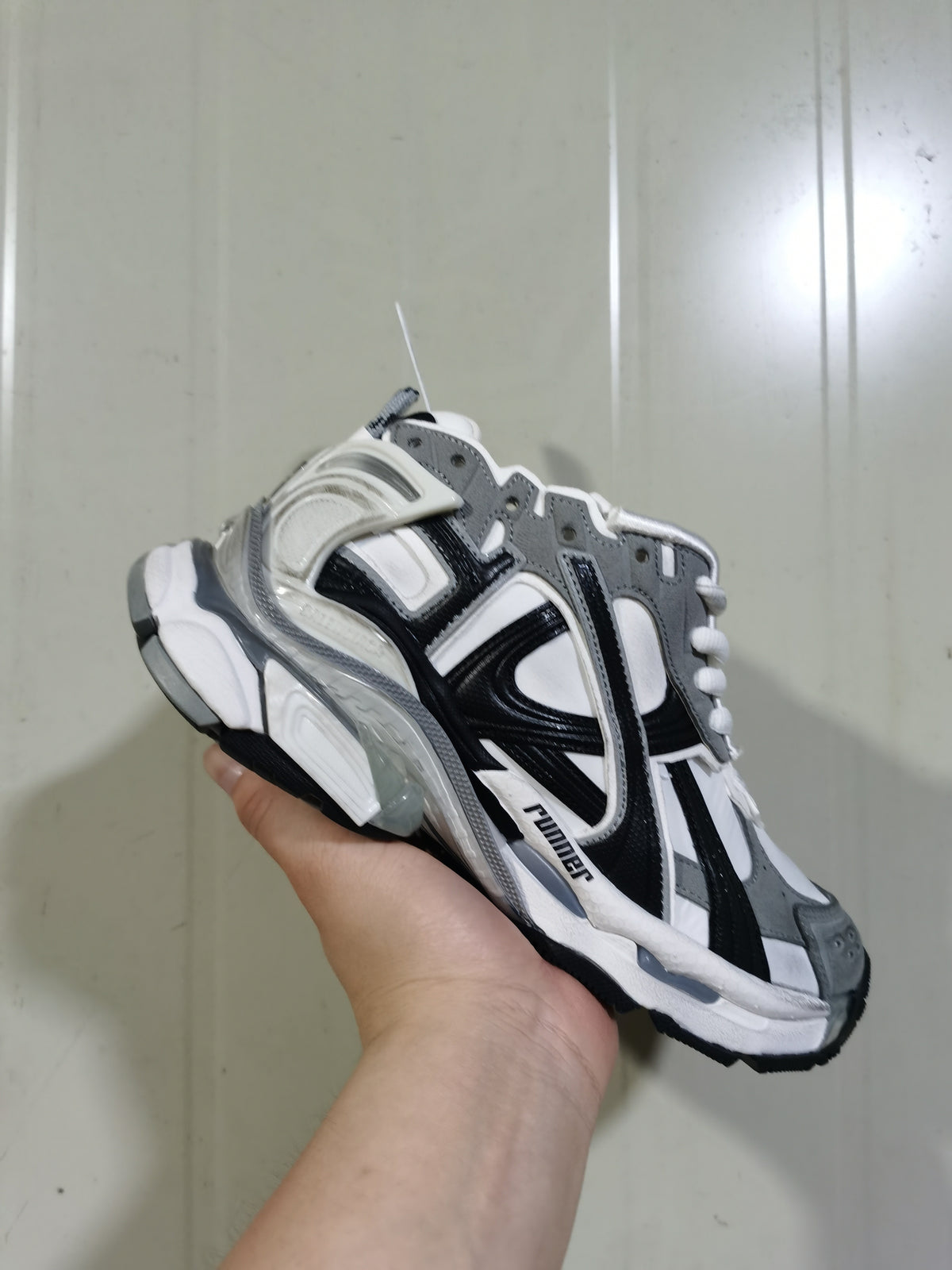 Front three-quarter view of the grey, white, and black Puma 9012 Runner sneaker with contrasting overlays and lace-up closure.