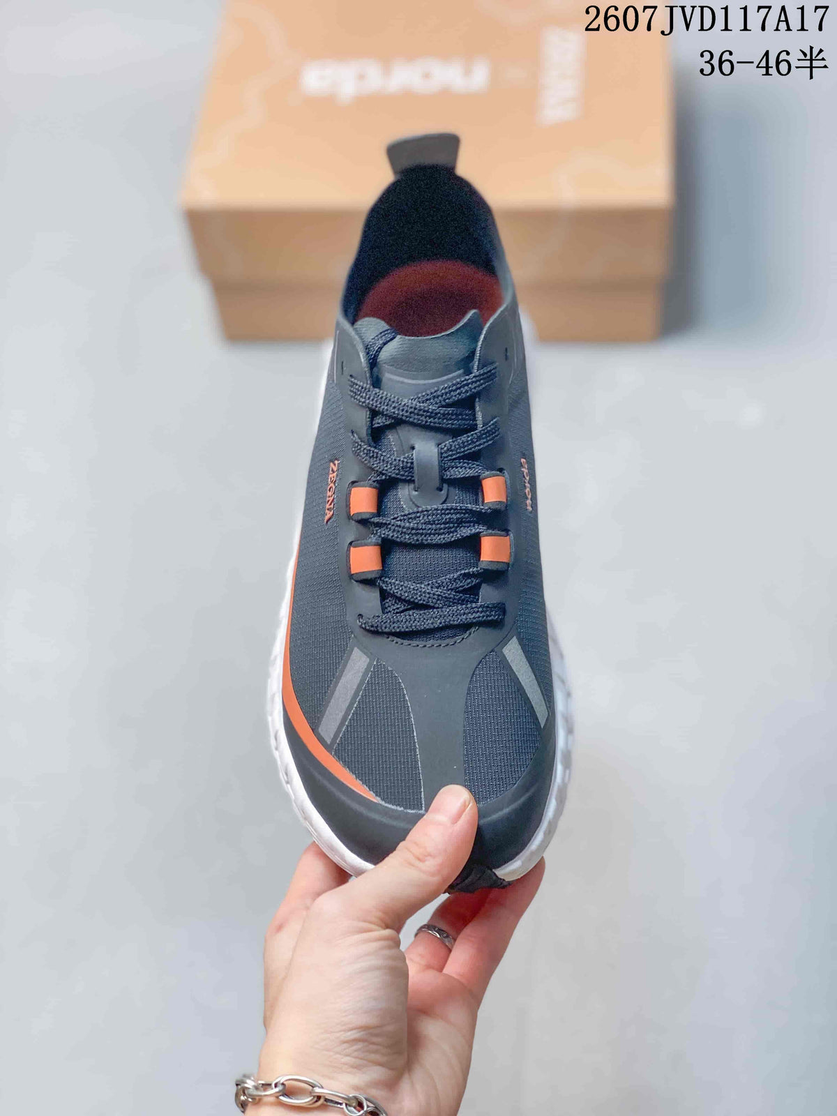 Top view showing the lace-up construction, dark gray upper, orange lace details, and protective toe area.