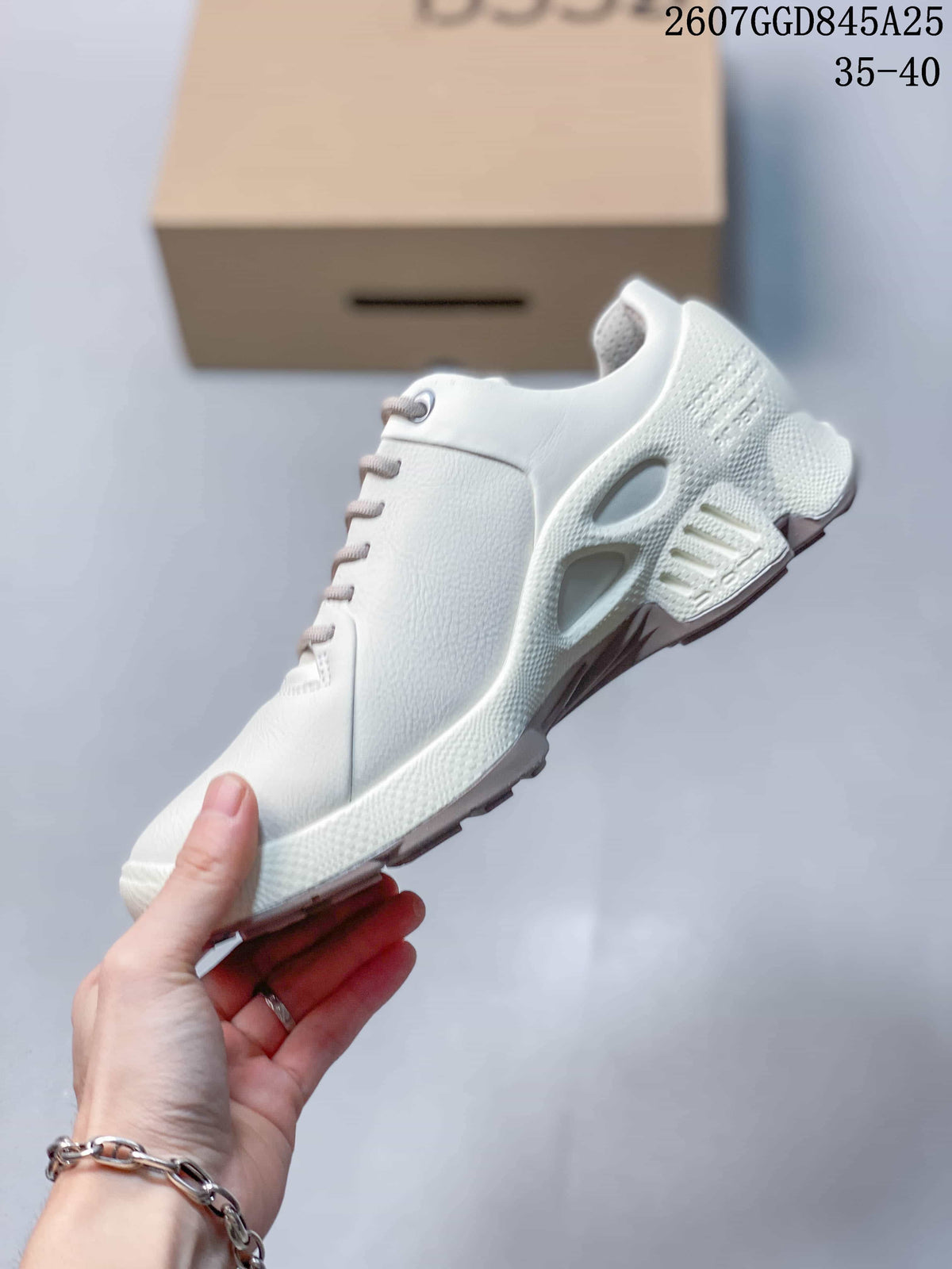 Side view of the white low-top sneaker showing the lace-up construction, perforated panels, and sculpted outsole.