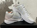 Pair of silver and white Nike Kobe basketball shoes shown from the side.