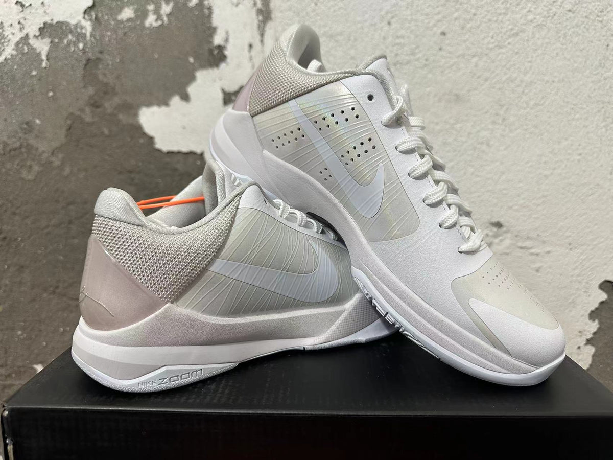 Pair of silver and white Nike Kobe basketball shoes shown from the side.