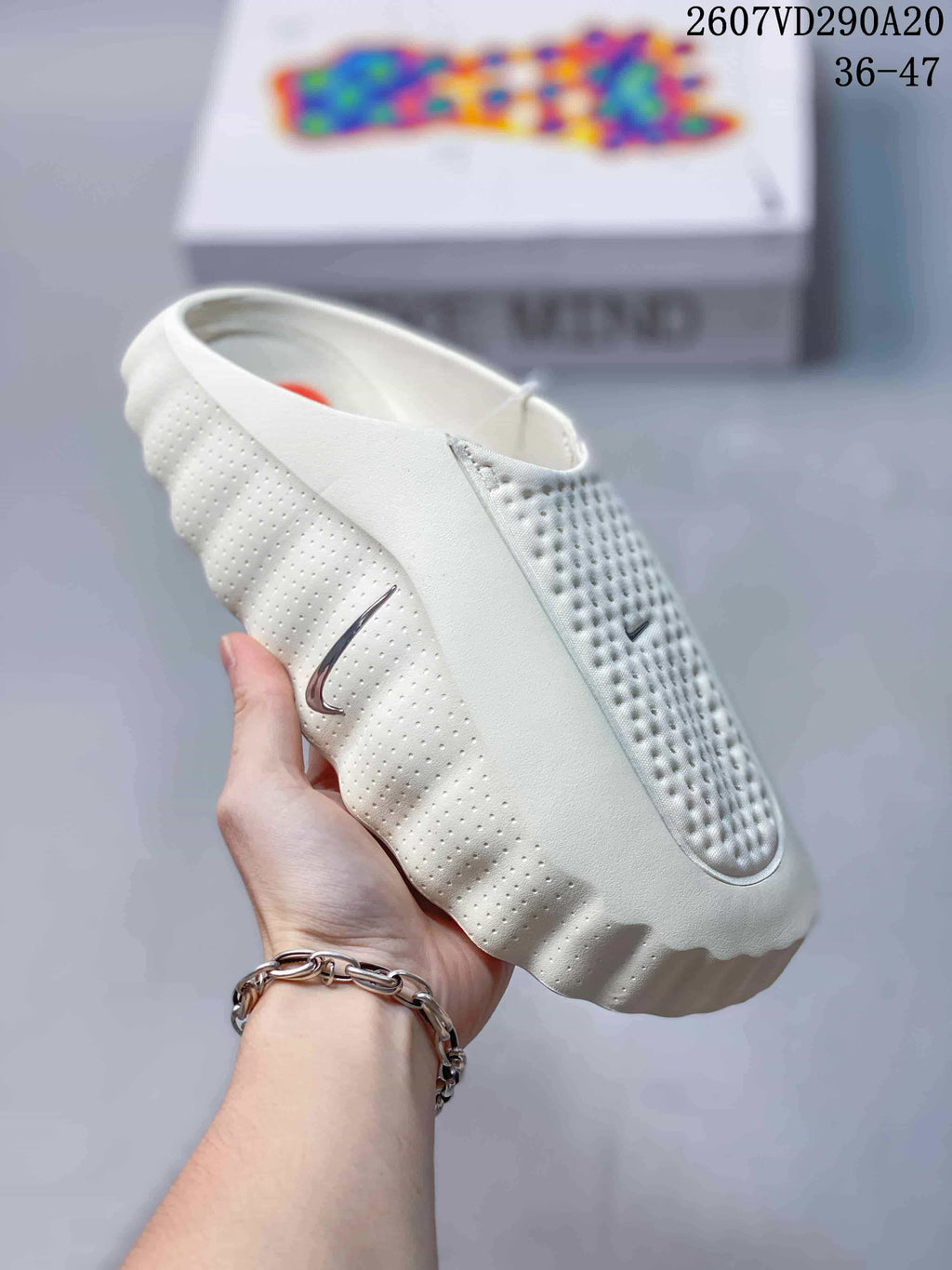 Close side view of a white Nike Mind 001 slide showing the perforated upper and textured sole edge.