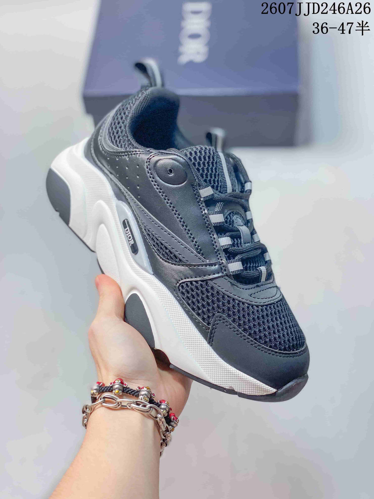 Angled side view of a black and white Dior sneaker showing the perforated side panel, mesh sections, branding, and thick sole.