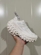 White Caterpillar Defender sneaker shown from the opposite side with mesh-like panels, laces, and deep outsole lugs.
