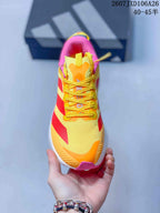 Top view showing the yellow lace-up upper, orange tongue details and pink collar.