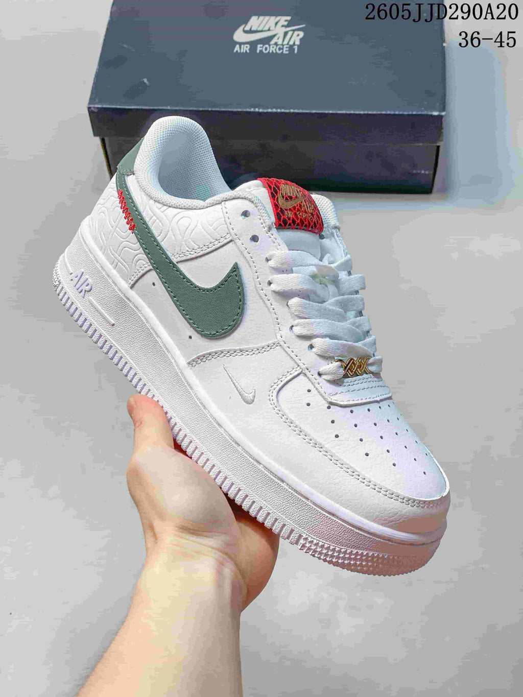 Angled side view of the white sneaker showing the green Swoosh, red tongue detail, layered upper, Air branding, and white rubber sole.