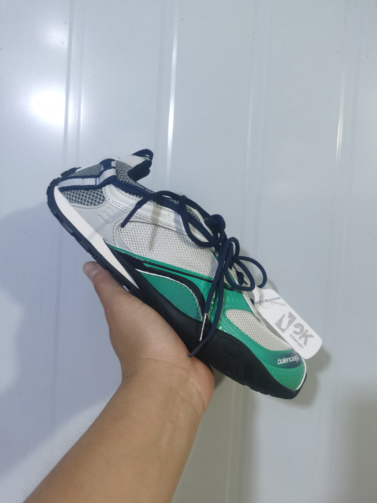 Angled view of the green, grey and black Balenciaga Radar sneaker showing the mesh panels, layered overlays and dark laces.