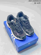Pair of dark adidas Response CL style sneakers displayed on a blue adidas shoebox.